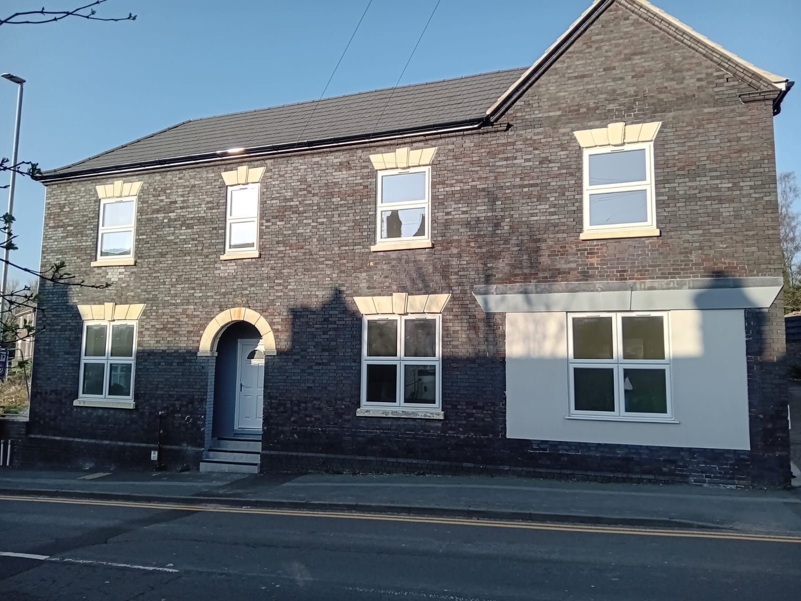 image of the front of a large grey brick home 