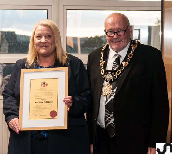 photo of a lady and mayor holding a framed certificate