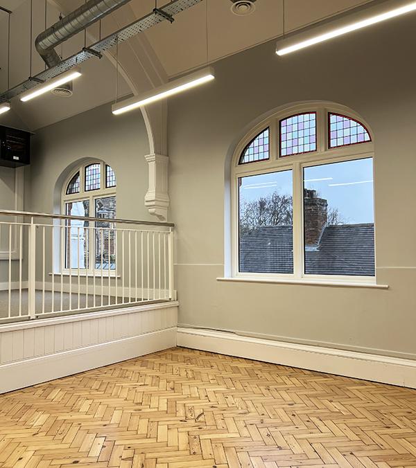 office with wooden flooring and arched windows