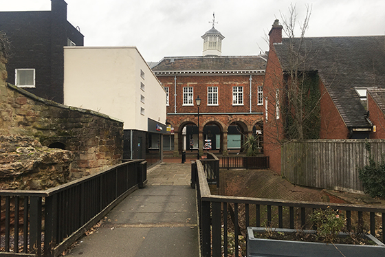 A view of a bridge leading towards the town hall with buildings either side