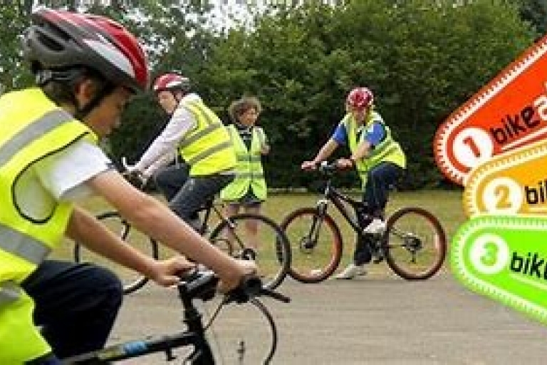 photo of a person wearing a hi-vis waistcoat and bike helmet, on a bike during a training session.