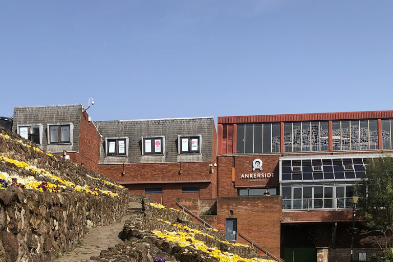 Ankerside shopping centre building with blue sky and flower beds