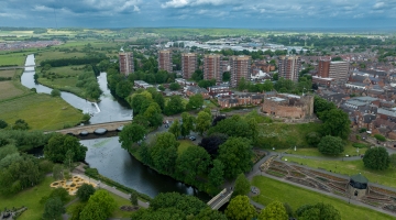 houses and flats drone view with a river and castle